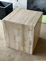 Single travertine cube side table showing front and top surfaces