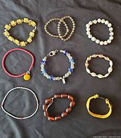 All nine bracelets laid out on black background