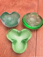 All three green glass bowls on wood surface