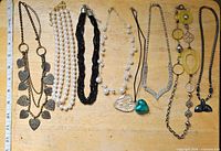 Group shot showing all eight necklaces laid out side by side