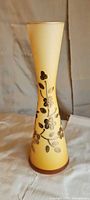 Front view of yellow ombre glass vase with raised gold floral motif