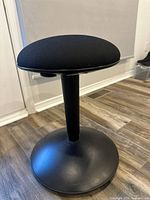 Full view of black NILSERIK stool showing seat, column and base
