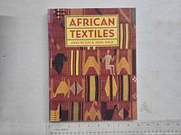 Front cover of the book showing the title 'African Textiles' and textile pattern designs.
