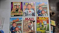 Photo of all 6 MAD Magazine issues laid out side by side showing covers clearly