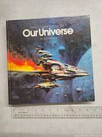 Front cover of the hardcover book showing a detailed spaceship and cosmic background.