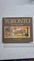 Front cover of the book titled 'Toronto: The Way it Was' showing an illustrated historical street scene in Toronto with buildings and cars.