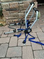 Overall view of the Thule 2-bike rack showing metal frame, blue straps, and black padding.