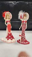 Two Bradford Exchange figurines in red and white detailed dresses with wide-brimmed hats