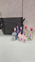 Black patterned baby diaper bag standing behind 10 baby care items arranged on a table.