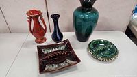 Five Blue Mountain Pottery pieces including vases, a dish, and an ashtray on a white surface