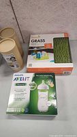 Boos Grass drying rack box and Philips Avent Natural baby bottle box side by side on a flat surface.