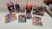 Lot overview with multiple toys showing Transformers, Incredibles, Hot Wheels packaging