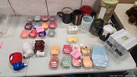 Top view of various Scentsy wax warmers and multiple wax melt bars laid out on table.