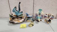 Photo showing all four vintage collectible bird figurines together on a surface.