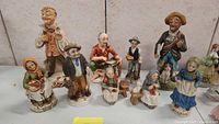 Overall view of all eleven vintage collectible figurines arranged in a group against a plain background.