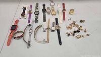 Wide shot of the lot showing all wristwatches and cufflinks laid out on a white surface.