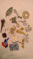 Wide view of all assorted costume jewellery brooches and pins showing variety of designs and colors.