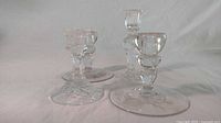 Group of assorted sizes of crystal dinner glasses showing varying heights and etched floral base pattern