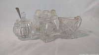 Five crystal serving items: three salt and pepper shakers, one mustard dish with silver spoon, and one Cambridge Fernland creamer.