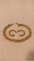 Photo of Monet gold tone French rope chain bracelet with lobster claw clasp and matching gold tone French rope chain hoop earrings with post backs.