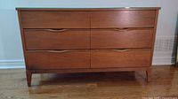 Front view of dresser without mirror showing six-drawer layout, integrated pull handles and walnut finish.