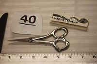 Full view of scissors with brand booklet and ruler showing 5.5 inch length