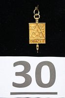Front view of gold Oracle pendant showing symbols and text