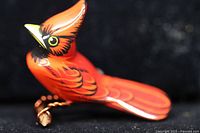 Left side profile of red cardinal pin showing carved details and copper wire perch