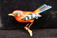 Front view of carved scarlet tanager brooch showing paint details