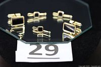 Full set of cufflinks and shirt studs displayed on glass
