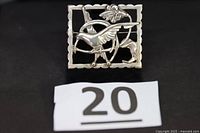 Front view of rectangular sterling silver brooch with bird design, reference number visible