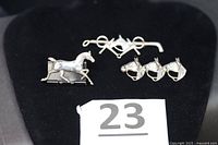 Group shot of all three sterling silver horse pins on black background