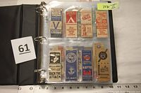 Binder page showing WWII themed matchbook covers such as "Back the Attack", U.S. Navy, U.S. Savings Bonds.