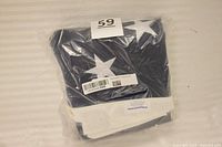Flag folded in sealed plastic bag with lot sticker visible
