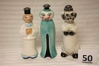 Front view of three figural ceramic sprinkler bottles with metal caps