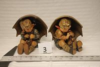 Both Hummel figurines side by side with ruler showing height