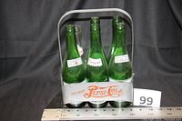 Carrier front view holding five green bottles
