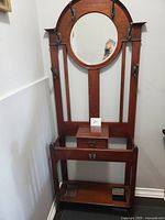Full view of wooden hall stand showing mirror, hooks, drawer, lower shelf and missing tray space
