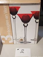 Retail box showing trio of red glass candle holders