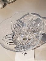 Top view of clear cut crystal bowl showing flower-form rim and gold label