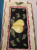 Close-up of ceramic tray centre artwork showing pear, grapes, leaves