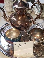 Full view of coffee/tea pot, sugar bowl, creamer on tray