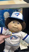 Close-up of doll wearing Blue Jays cap and jersey