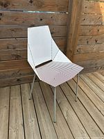 Front/side view of chair against wooden fence