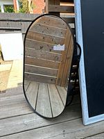 Front view of oval mirror with black frame
