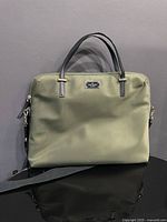 Front view of olive green Kate Spade laptop bag showing handles and overall condition