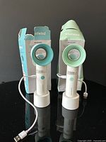 Front view of both Merkury Whirlwind fans with USB cables and boxes