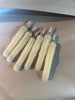 Six ivory LED drip candles laid out together