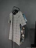 Side view of four dresses on hanger stand