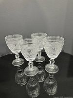 Front view of all four pressed glass goblets
